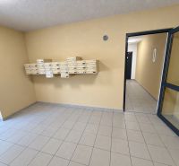 Lobby with mailboxes in a two-room apartment building, with tiled flooring.