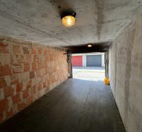 The interior of a garage with unfinished walls and a floor with a wooden decor.