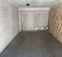 The interior of a garage with concrete walls and a floor with a wooden decor.