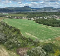 Agricultural and forest lands in Žilina with a village and hills in the background.