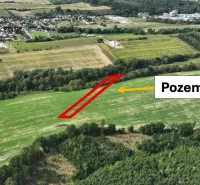 Agricultural and forest lands in the Žilina area with nearby urban developments and greenery.