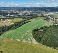 Aerial view of agricultural and forest lands near Žilina with the city in the background.
