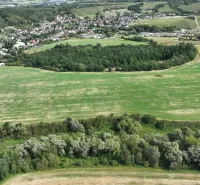 An aerial view of agricultural and forest lands around Žilina with scattered buildings.