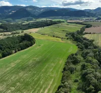 Aerial view of agricultural and forest lands around Žilina with a mountainous scenery.