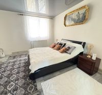 Bedroom in a family house with a bed, carpet, and a picture on the wall.