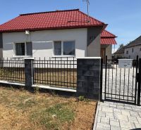 A family house on Hlavná Street in Bežovce with a red roof and a wrought iron fence.
