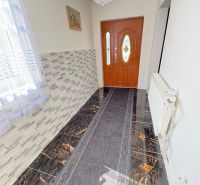 A hallway in a family house with distinctive tiles and a chandelier.