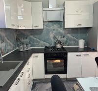 A kitchen unit in a family house with the elegance of a marble wall and modern appliances.