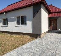 A family house on Hlavná Street in Bežovce with a red roof and a paved walkway.