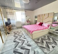 Bright bedroom in a family house with a pink bed and a wooden decor floor.
