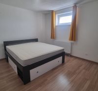 Bedroom with a bed, window, and yellow curtains, floor with wooden decor.