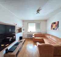Living room with a light sofa, furniture, and flooring with a wood decor in a 3-room apartment.
