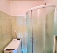 A bathroom with a washing machine and a shower in a 3-room apartment.