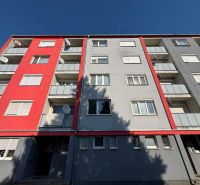 Colorful facade of a 3-room apartment building on the street in Bajč with satellites.