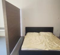 Bedroom with a bed and a desk in a 2-room apartment.