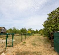 The garden at the family house on Topolianska Street in Michalovce with fencing and shrubs.
