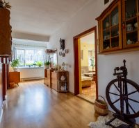 A hallway of a family house with a wooden decor floor, furniture, and decorations.