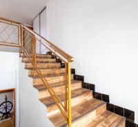 A staircase with a wooden decor floor and metal railing in a family house.
