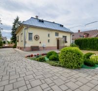 A family house on Topolianska Street in Michalovce with a landscaped garden and a paved road.