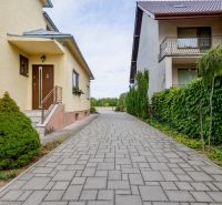 A view of a family house on Topolianska Street in Michalovce with paving and greenery.
