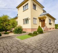 A family house on Topolianska Street in Michalovce with a landscaped garden and paving.