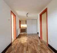 A hallway in a family house with a wooden decor floor and orange door frames.