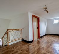 Interior of a family house with a wooden decor floor and a staircase.