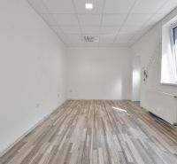 Commercial space with a large window, white walls, and a floor with a wood decor.
