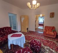 Living room in a family house with retro furniture and a tiled stove.