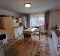 A kitchen in a family house with a dining table, equipped with white cabinets.