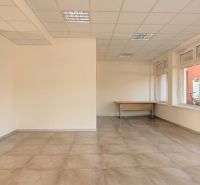 Empty office with large windows and a desk, floor with wood decor.