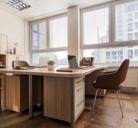 Offices with wooden decor furniture, a large table, and a view of the city through the windows.