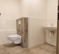 Office restroom with tiled floor and wall-mounted toilet.