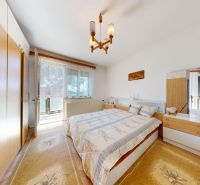 Bedroom in a family house with a double bed, wardrobes, and a large window.