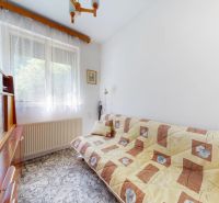Room with a sofa, shelf, and window in a family house, carpeted floor.