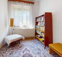 Cozy study with a bookshelf and an armchair in a family house.