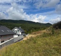 Plots - housing in Považská Bystrica with a view of the mountains and cloudy sky.