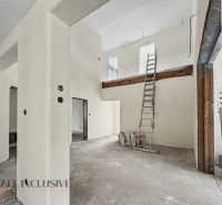 The interior of a family house under construction with a ladder and white walls.