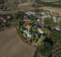 Development plots in Slatinské Lazy surrounded by fields and greenery.