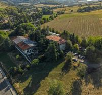 Aerial view of development plots in Slatinské Lazy with an old building and nature.