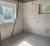 The construction of a room in a family house, white bricks and windows provide light.