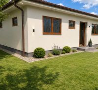 A family house in Šamorín with a well-maintained lawn and simple garden planting.