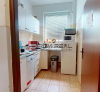 Offices with a furnished kitchenette, including appliances and storage space.