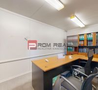 Office with desks, an office chair, shelves, and document trays.