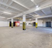 Interior of warehouses and halls with concrete floors and columns equipped with safety stripes.