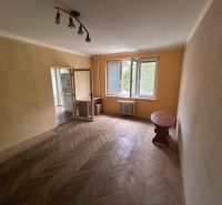 A room in a 3-room apartment with a wooden decor floor and an open window.