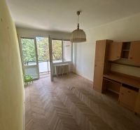 A room with furniture, a wooden decor floor, a balcony in a 3-room apartment.