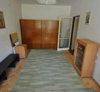 A room in a 3-room apartment with a carpet, cabinets, and a floor with a wood decor.