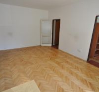 A room with a wooden floor decor and a kitchen, 3-room apartment.