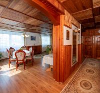 A dining room in a family house with a wood-patterned floor and wooden paneling.